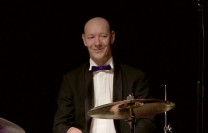 <strong>Ren&eacute; Vreugde</strong> - Drums<br /><p>Ren&eacute; Vreugde studeerde in 1998 af als uitvoerend en docerend musicus aan de faculteit Lichte Muziek van het Utrechts Conservatorium. Al op vijfjarige leeftijd raakte Ren&eacute; in de ban van alles wat maar met trommels te maken heeft. Hij volgde drumlessen aan de muziekschool Breda waar hij les kreeg van Ad Gobbes, Leo van Lieshout en Marc Zoutendijk. Op 14 jarige leeftijd begon Ren&eacute; met het spelen in bands en orkesten in de meest uiteenlopende stijlen. Aan het Utrechts Conservatorium kreeg Ren&eacute; les van onder meer David Weiss, Gerhard Jeltes en Ben Gerritsen. Tevens volgde hij daar masterclasses van drum-grootheden als Jeff Hamilton, John Engels en Cindy Blackman. Ren&eacute; speelde als drummer en mede-oprichter in de fameuze band "Jazzconnection" en trad met hen over de gehele wereld op. Ren&eacute; Vreugde is een groot vakman &eacute;n liefhebber van alles wat met theater en muziek te maken heeft. Daarom voelt hij zich als slagwerker helemaal thuis bij 'Tour de Toon'.&nbsp;</p>